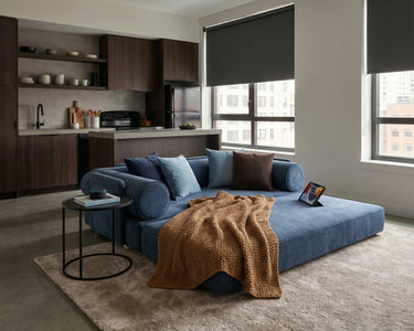 S8 Sleeper Sofa Bed in bed mode, styled with a throw blanket, cushions, and a side table.