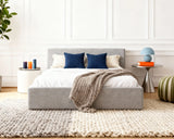 O2 Bed Cloud Frame, viewed straight on from the front, styled with navy and cream pillows, a cozy knit throw, and modern decor in a bright bedroom.