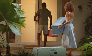 A couple carrying the boxed sofa inside, easily fitting through a doorway.