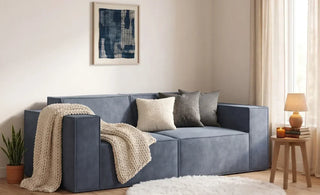 modular sofa on a small living room with round rug and a blanket on the loveseat