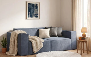 modular sofa on a small living room with round rug and a blanket on the loveseat