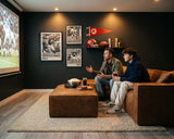 Two men playing video games with controllers in their hands, sitting on the M1 Sofa Sectional.