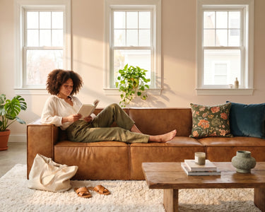 A woman relaxing and reading on the M1 Sofa Sectional.