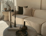 #color_inactive
A cozy beige modular sofa with minimal decor, featuring two candles and a Kinfolk book on the ottoman in a softly lit living room