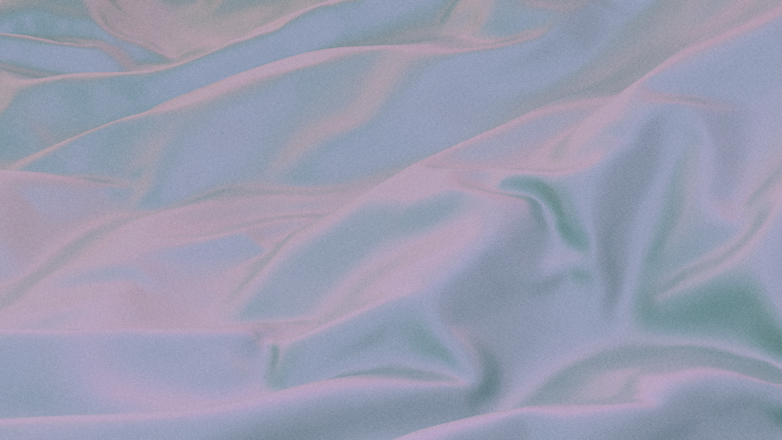 A close-up of a pastel-colored fabric with smooth, flowing folds, showcasing the soft texture and gentle sheen