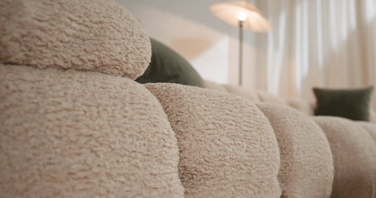 Close-up of a textured beige sofa with a blurred indoor background
